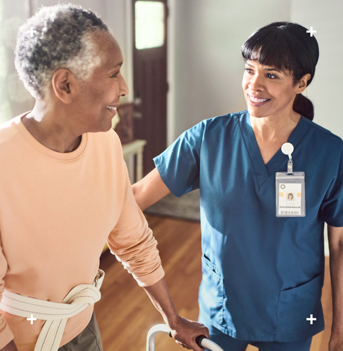 Nurse helping elderly lady with a walker at home