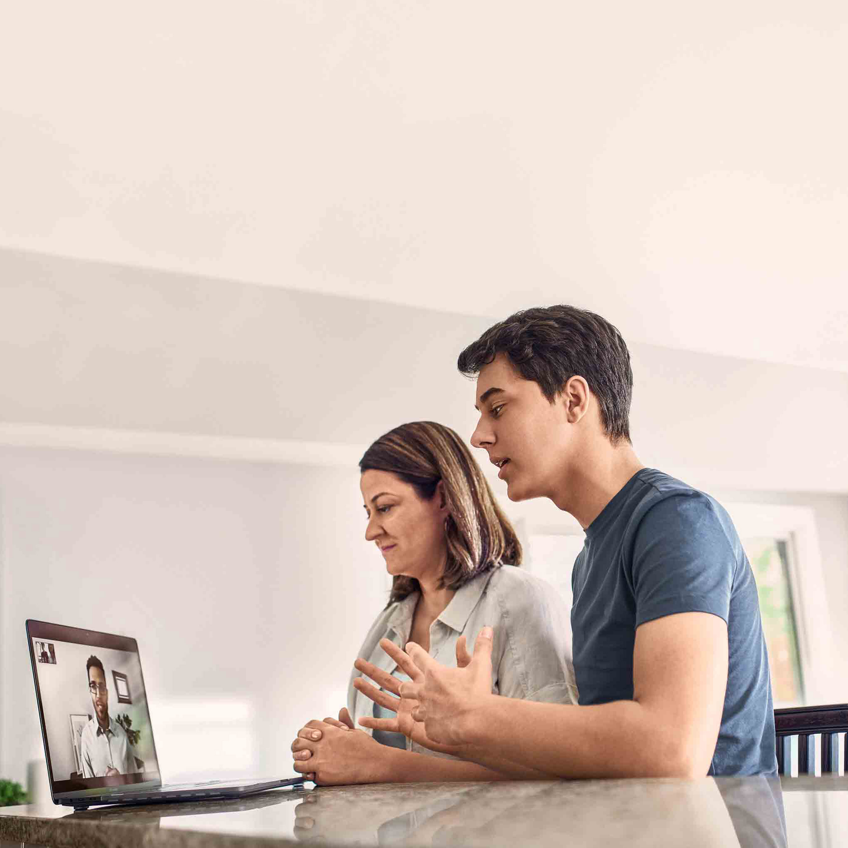 Mother and son talking to physician on a computer