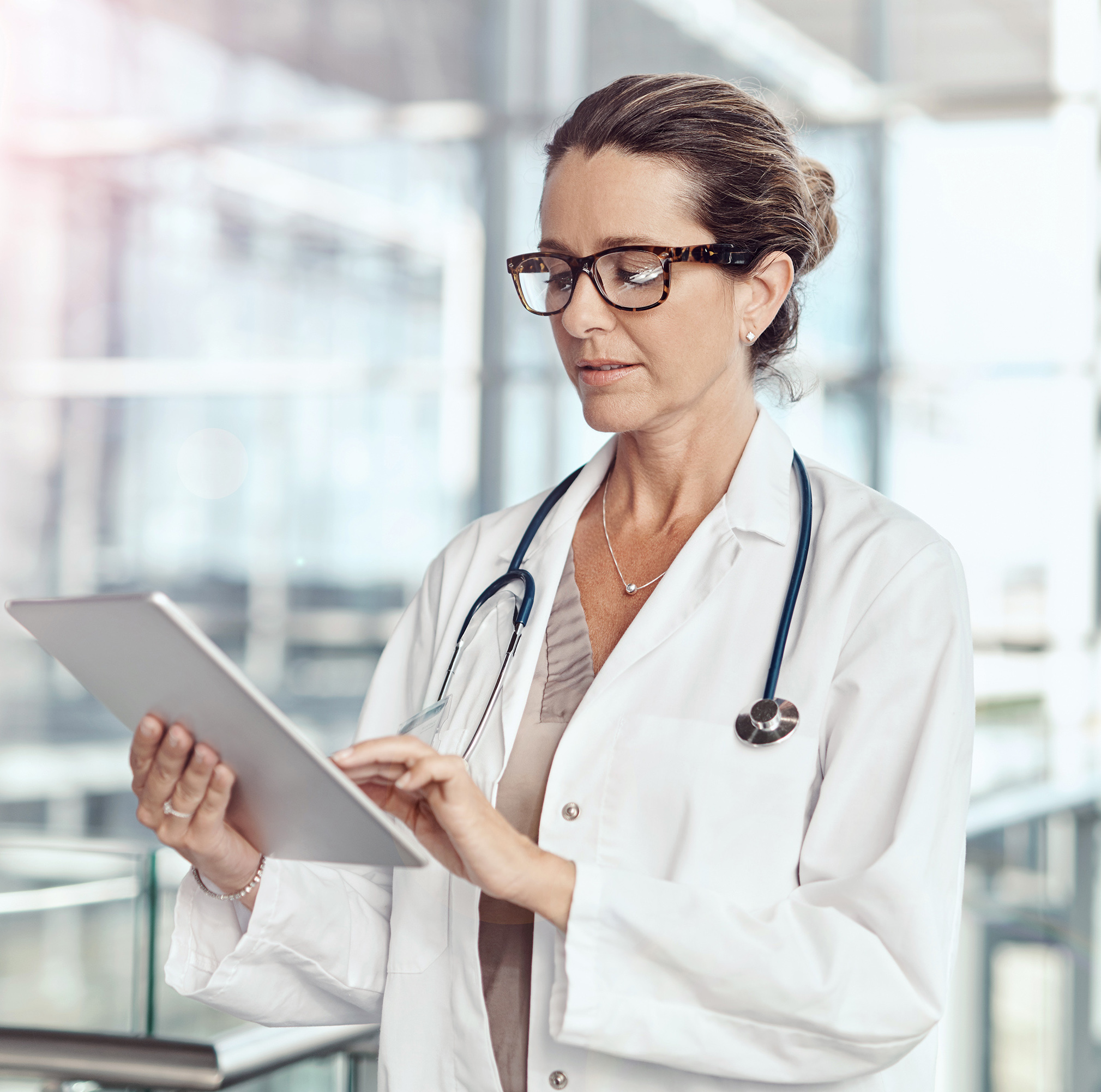 A doctor reviews information on a tablet