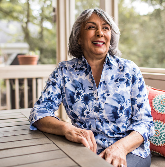 woman sitting on a screened porch and smiling