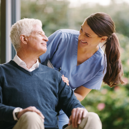 Sitting patient and happy caregiver share a laugh