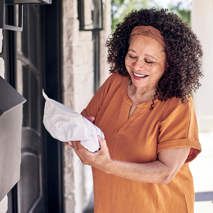 A person takes a package from their mailbox