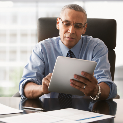 Bespectacled gentleman interacting with tablet