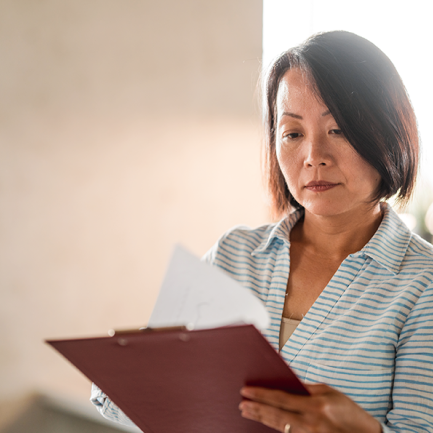 A person reviews papers on a clipboard