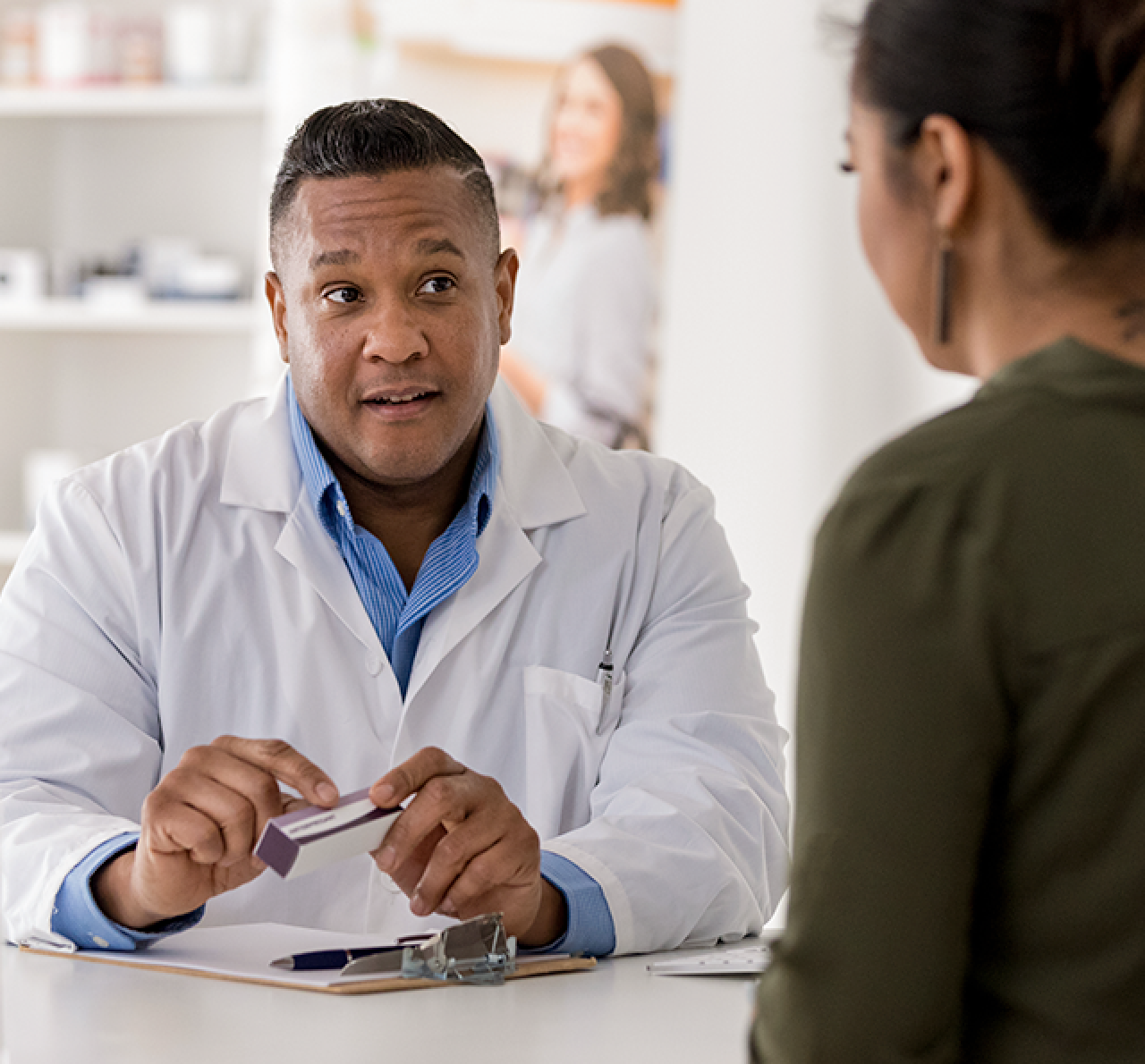 A pharmacist speaks with a patient.