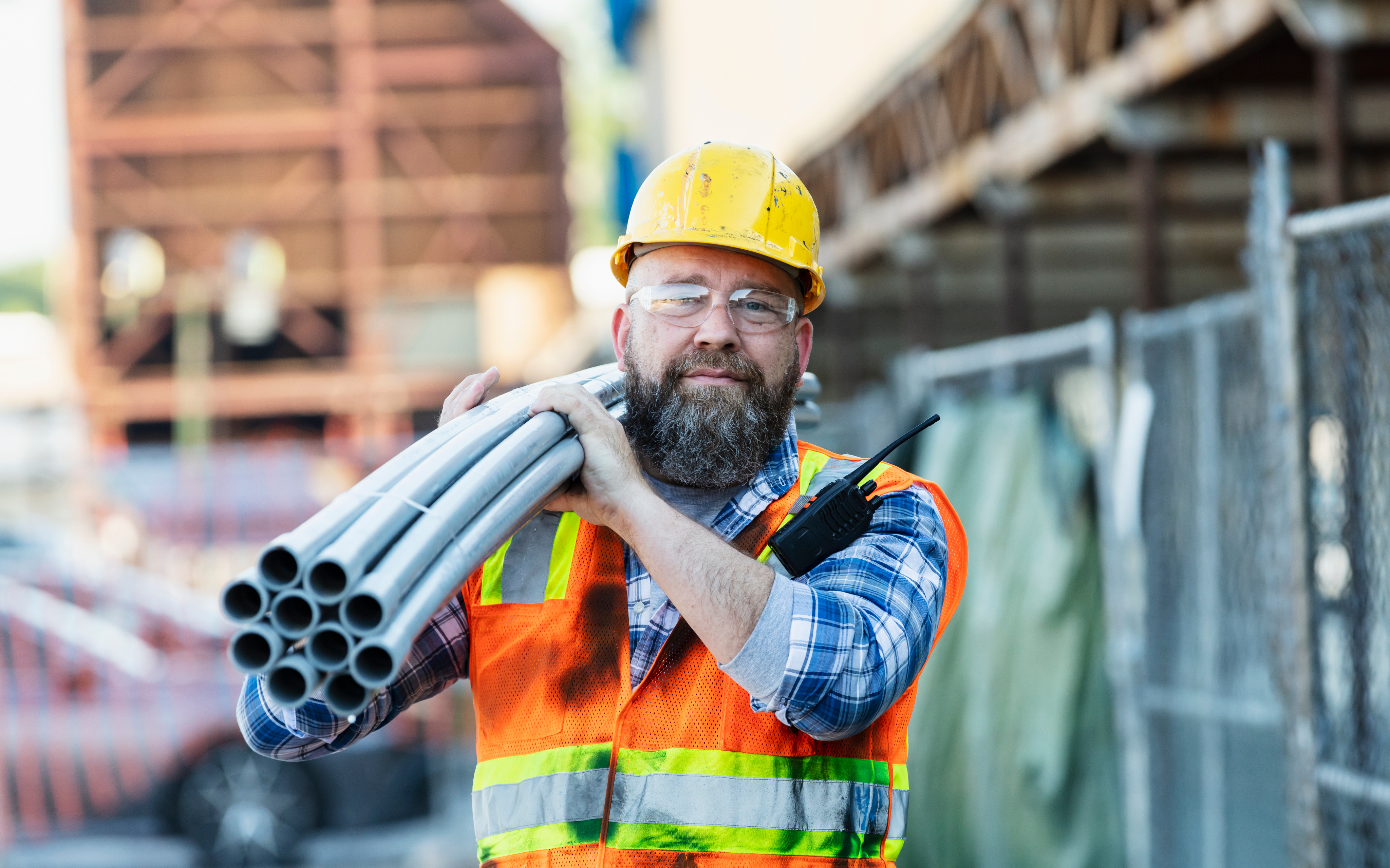 Construction Man carrying pipes