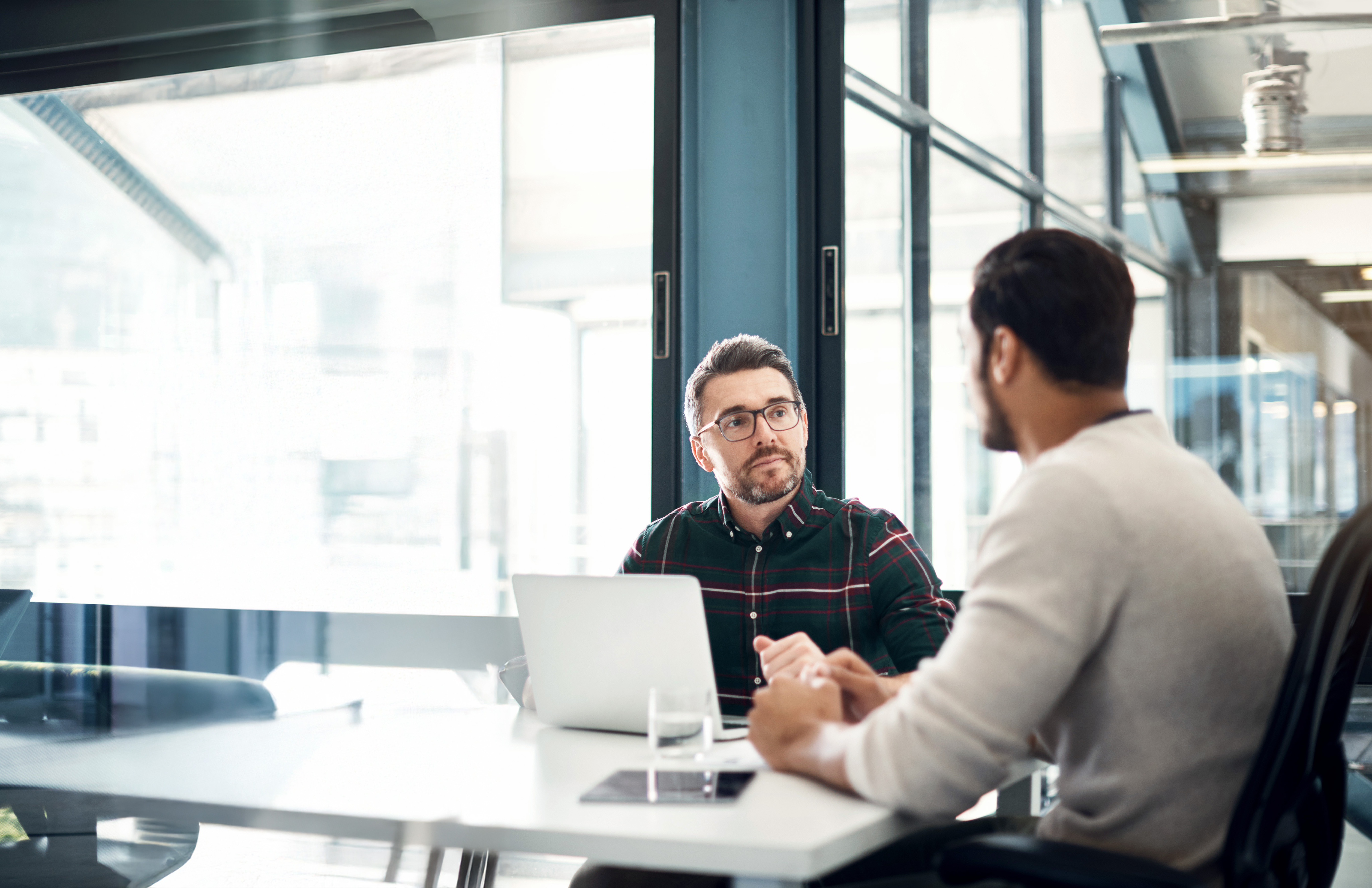 Two men talking at conference table