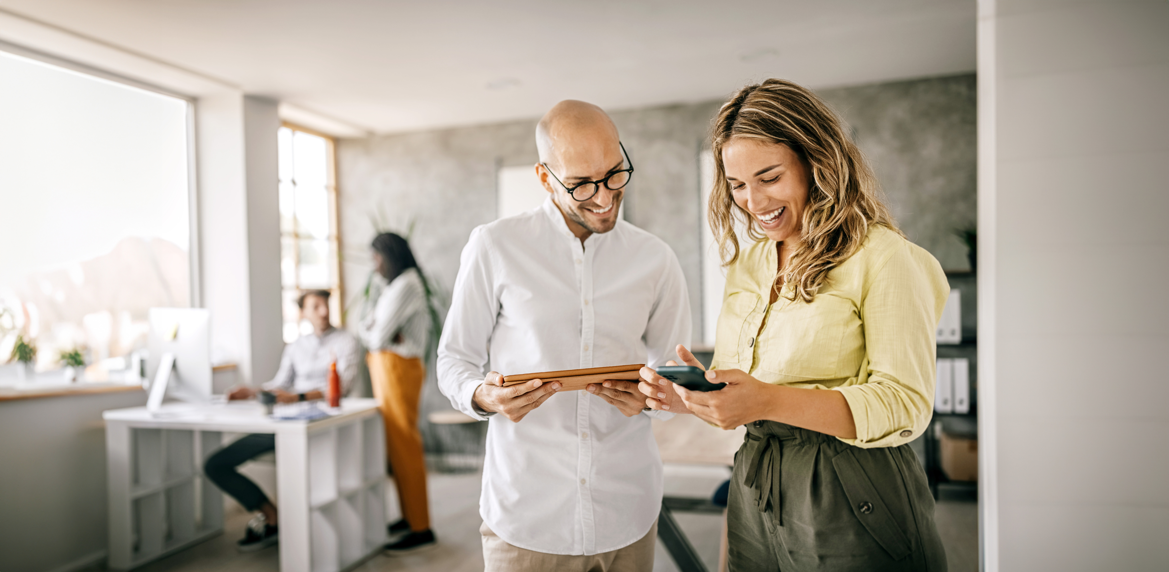 man and woman reviewing mobile phone