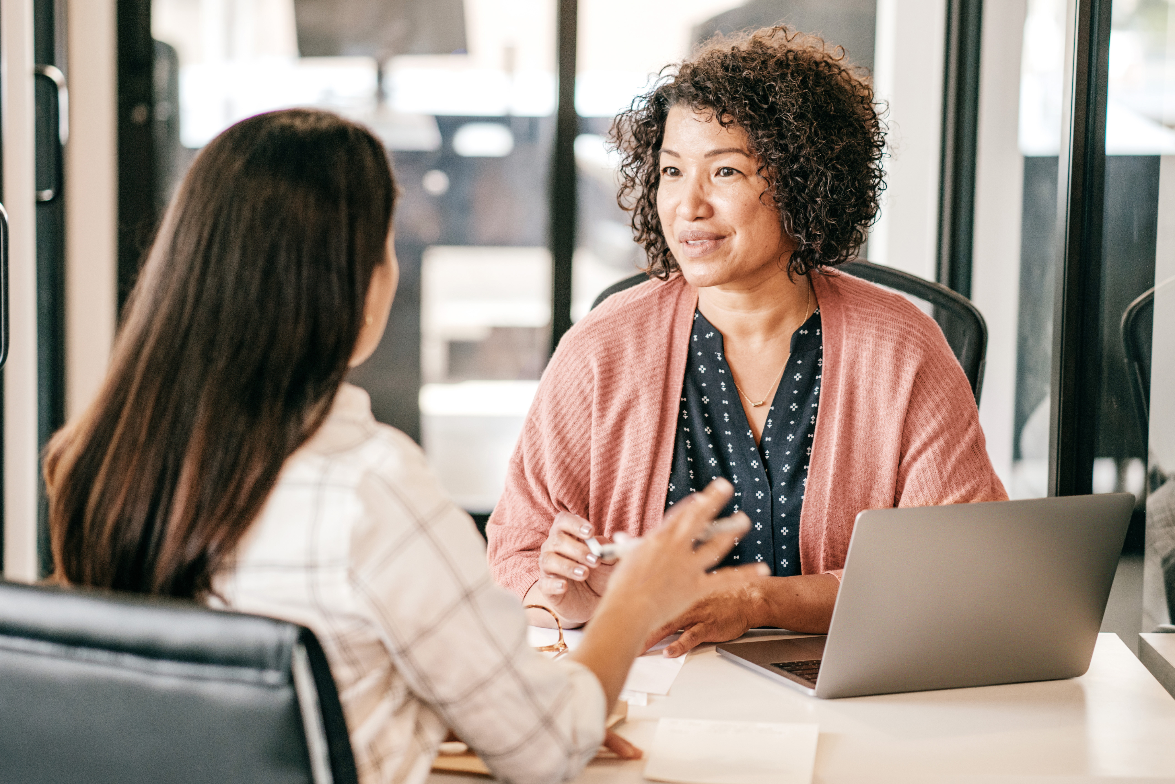 women talking across table