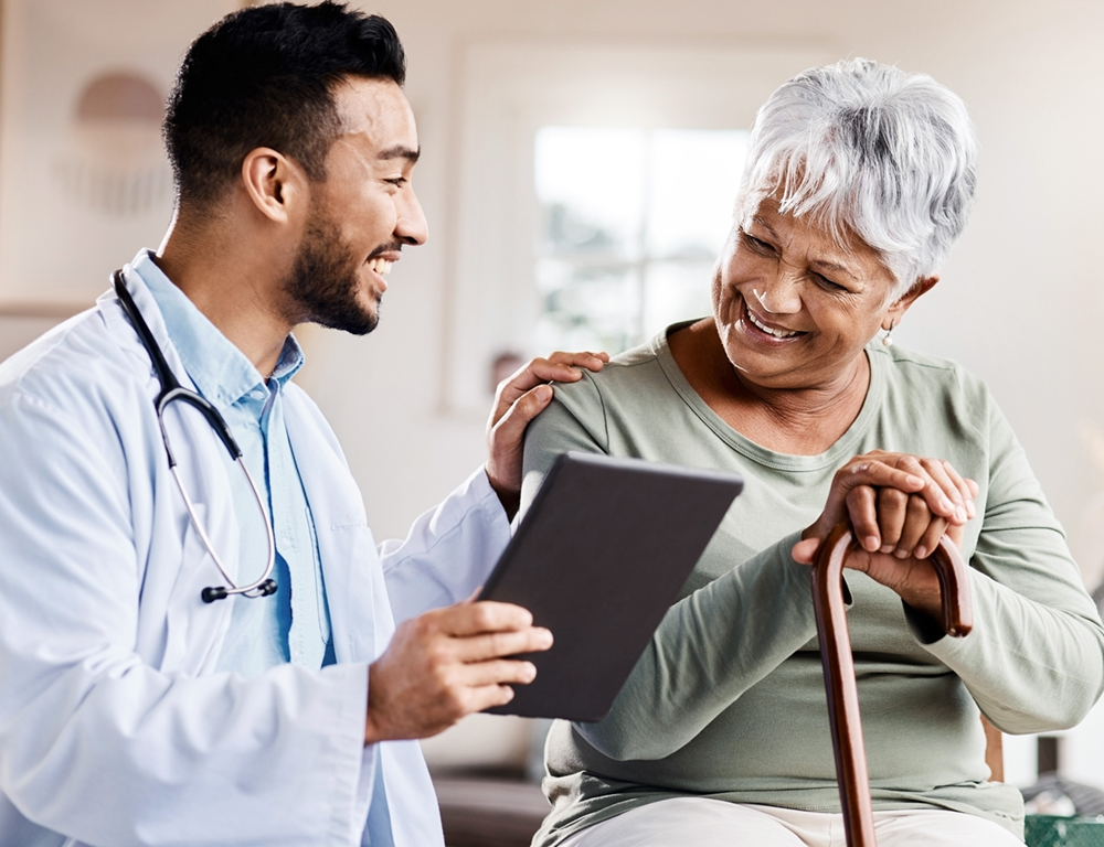 Young male physician talking with elderly female patient