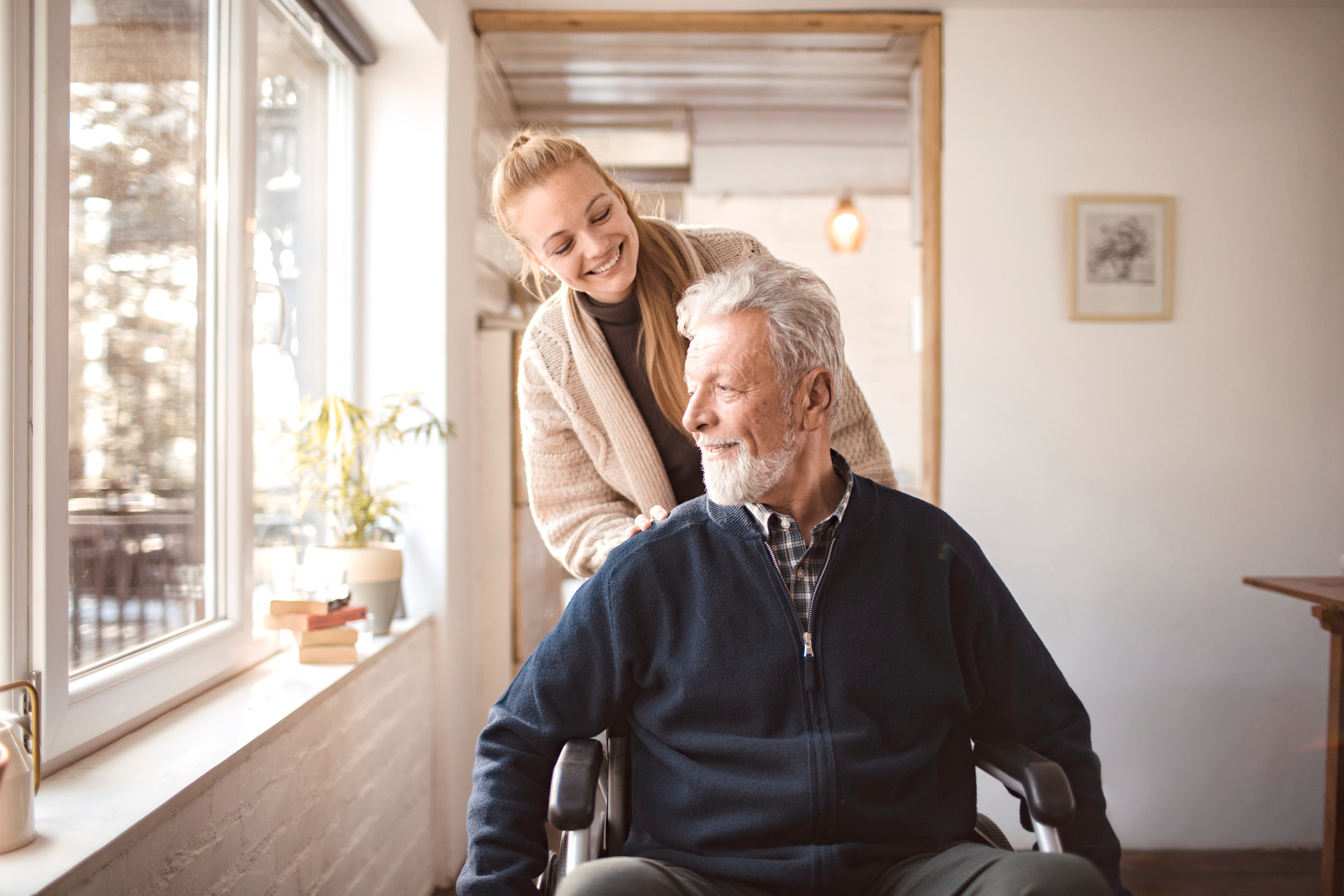 older elderly male pushed in wheelchair by female