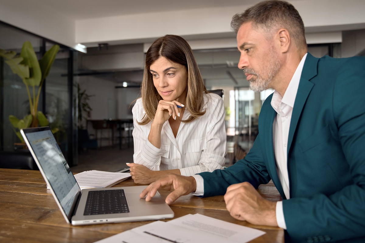 male and female looking at desktop computer