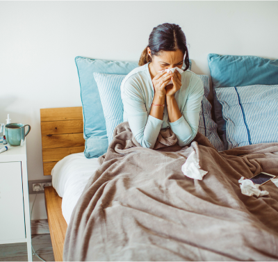 woman in bed and sneezing