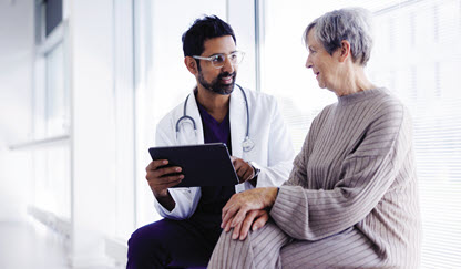 elderly woman meets with her health care provider