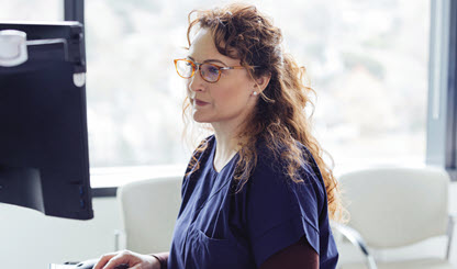 health care provider typing at a computer terminal