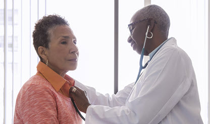 health care provider listens to her patient's heartbeat