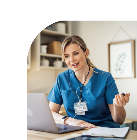 health care professional at her desk, speaking to someone on a virtual meeting