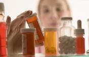 Woman gazing into a crowded medicine cabinet