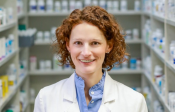 Image of Dr. Stephanie Smith Cooney standing in a pharmacy wearing a lab coat