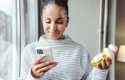 Woman looking at phone and medication