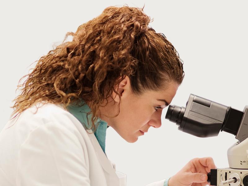 Woman looking through microscope