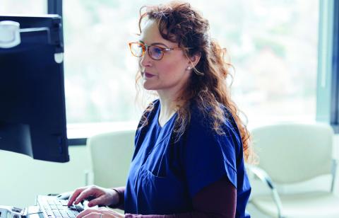 health care provider typing an email into her computer