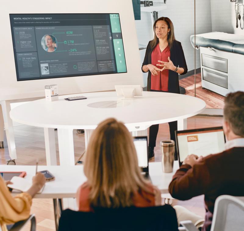 a woman gives a presentation to a group of people in an office setting