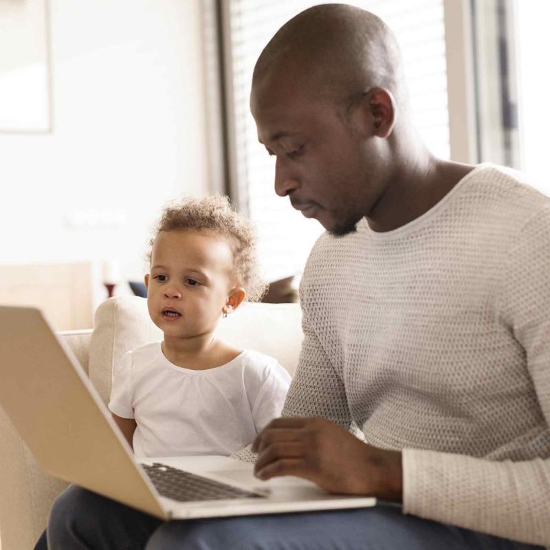 Dad with child checking doctor appointment on computer