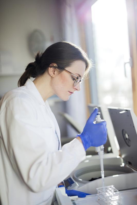 woman scientist eyeglasses blue glove on right hand faces right holds joystick button