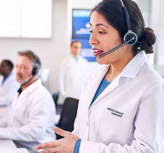 Woman in pharmacist jacket wears headset offers service