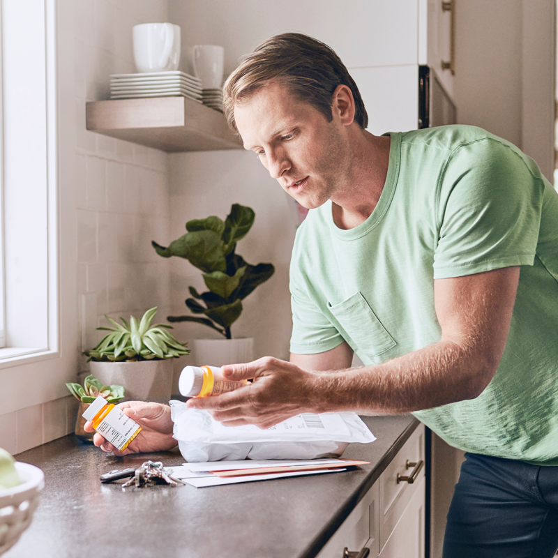 Man with holding 2 bottles of prescription medication