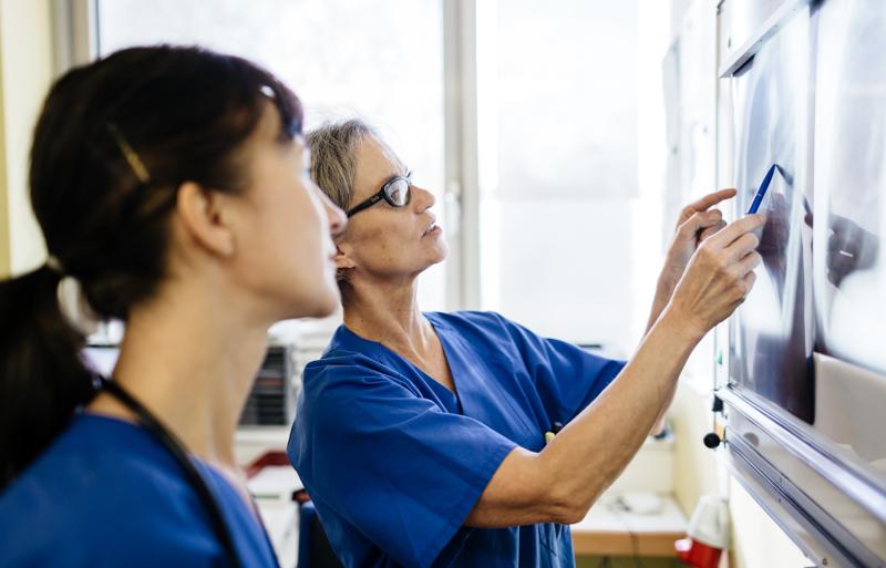 Two medical professionals review an x-ray image