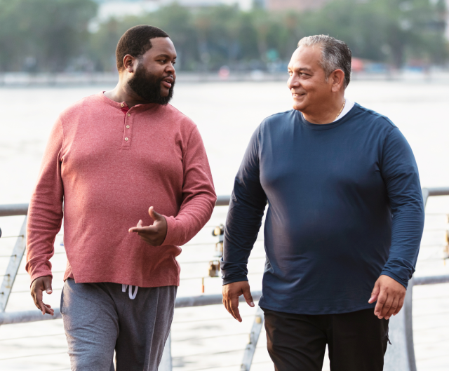 Two men conversing and walking along the pier