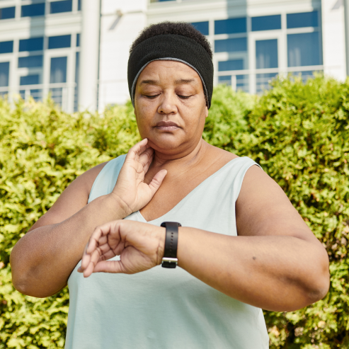 A person checks the time on their watch while exercising outside