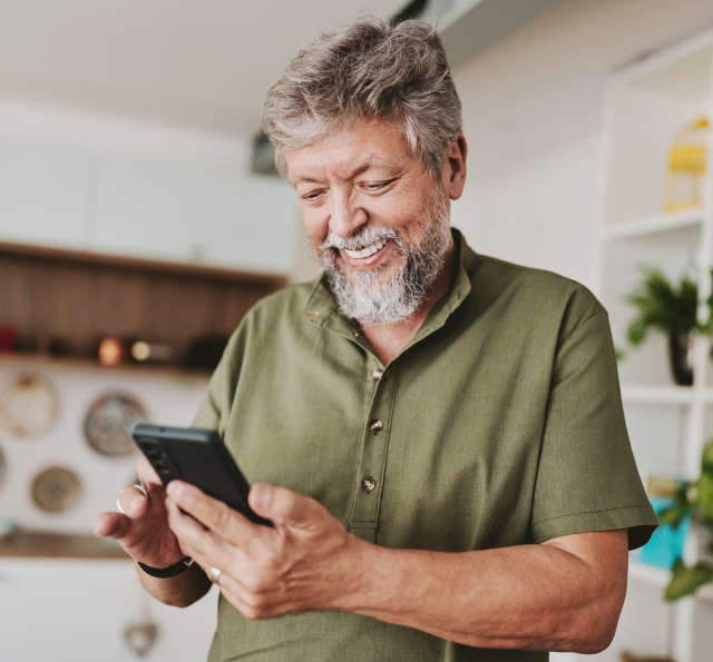 Smiling gentleman looks down at his smartphone