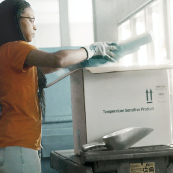 Health service representative packing pharmaceuticals in a shipping box for distribution