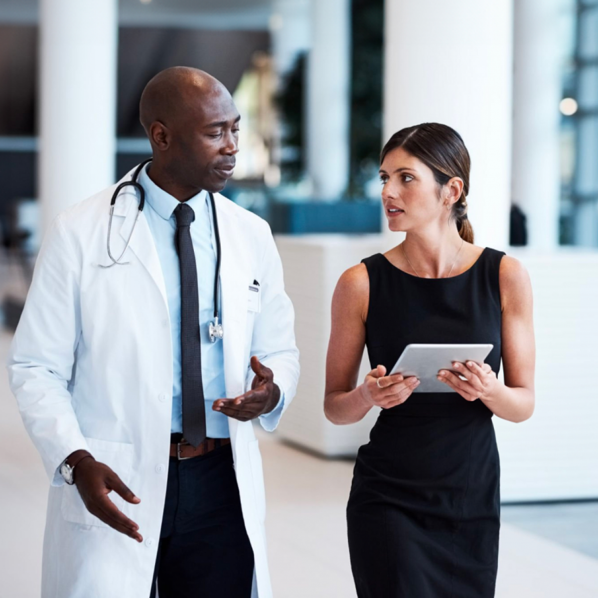 A woman walks and talks with a physician.