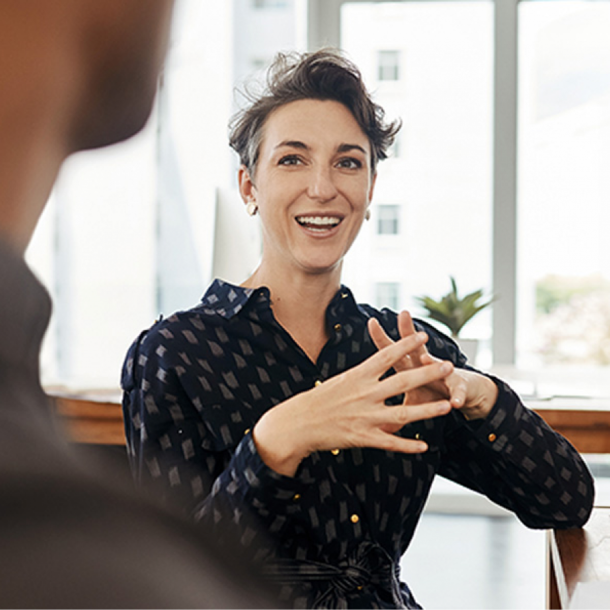 A person smile and talks with their hands