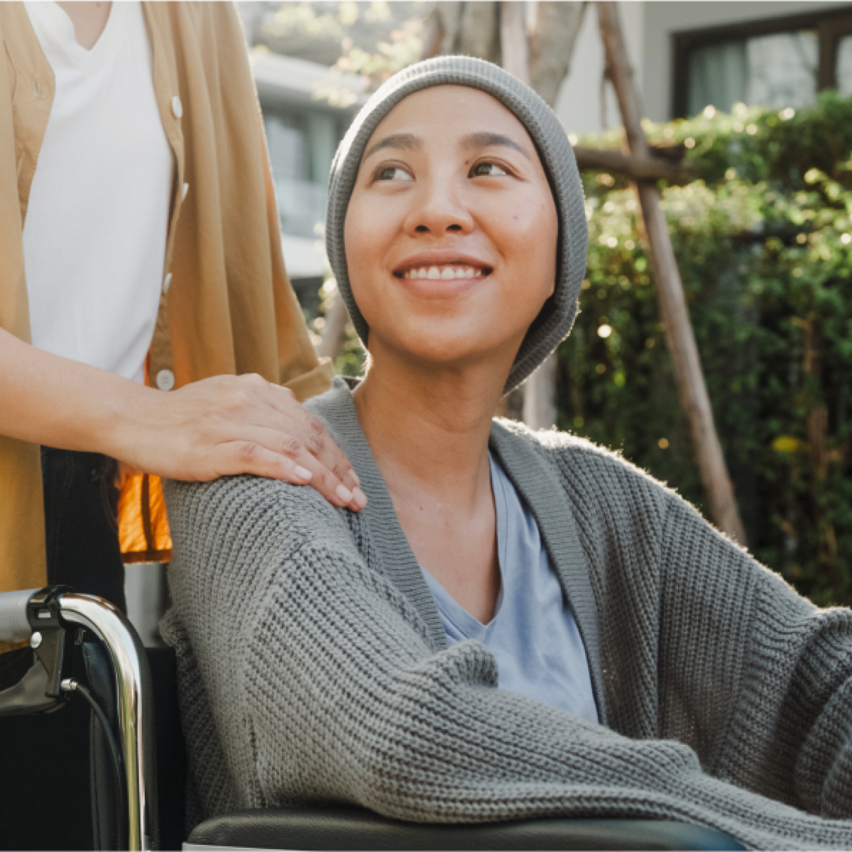 Smiling woman sits outside in wheelchair