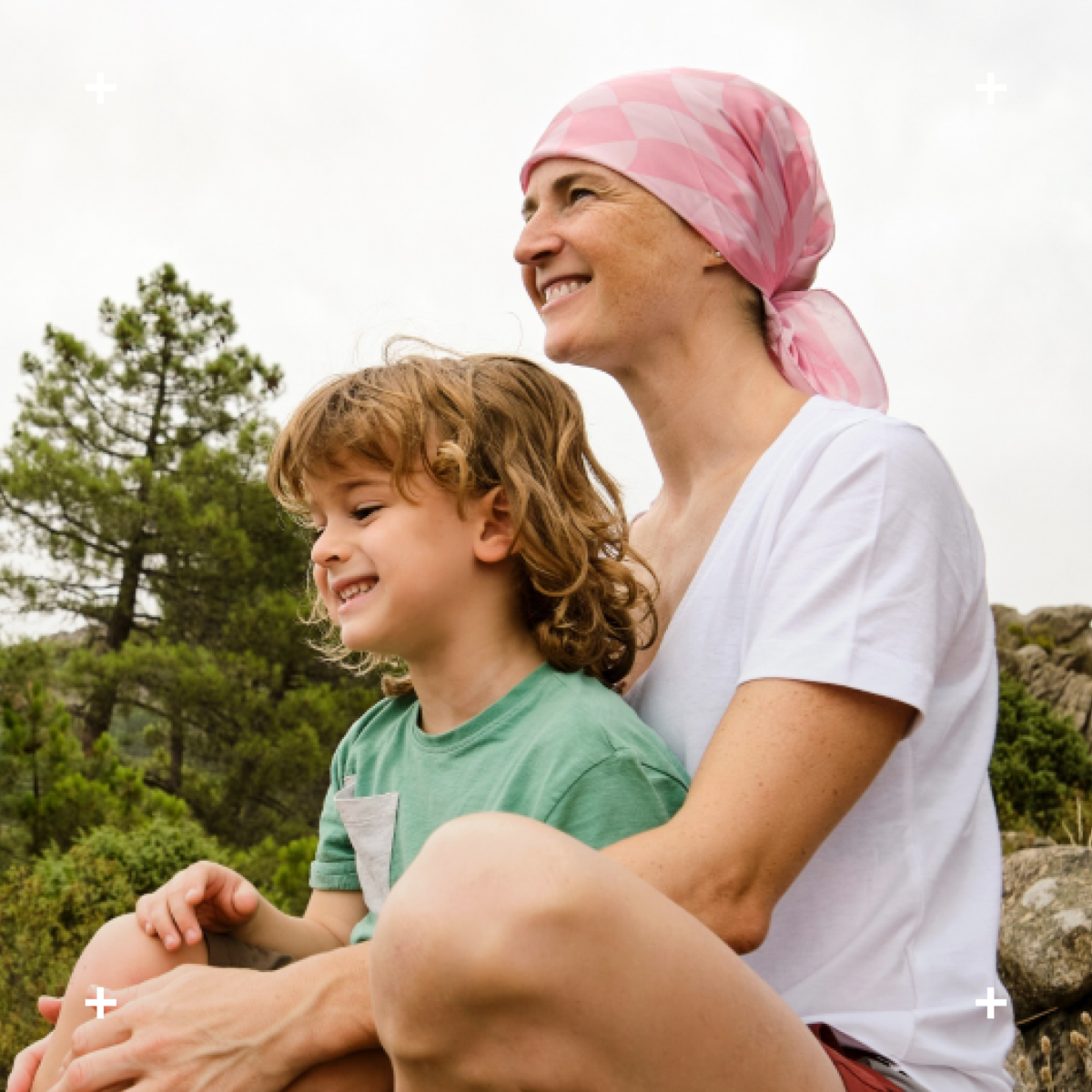 Woman with pink headscarf holds a child