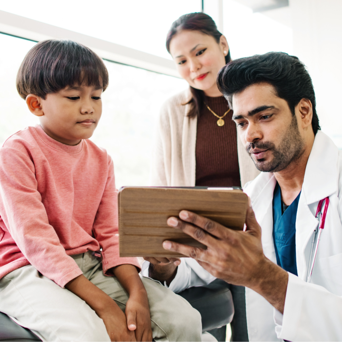 A doctor consults with a young patient and their parent