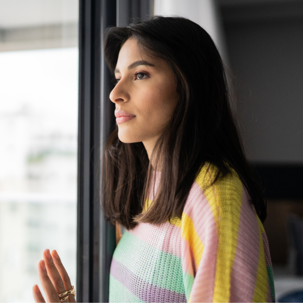 A woman looks out a window