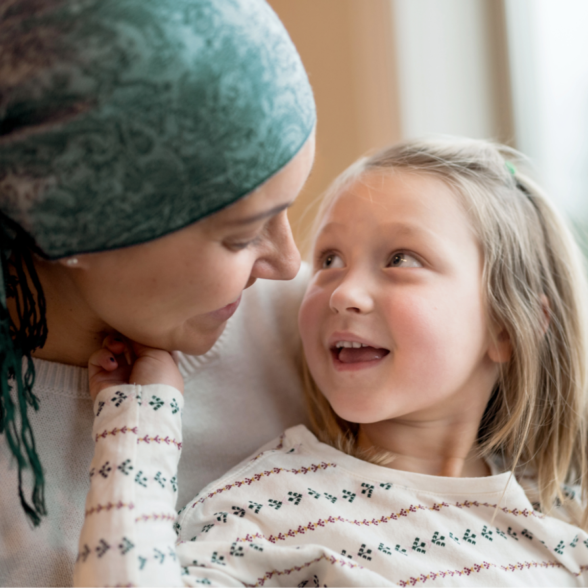 A child sits on the lap of a loved one who has cancer